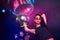 Beautiful young girl have fun, dancing in the night club. Holding party ball