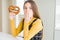 Beautiful young girl kid eating german snack salty pretzel cover mouth with hand shocked with shame for mistake, expression of