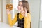 Beautiful young girl kid eating german snack salty pretzel doing ok sign with fingers, excellent symbol