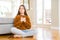 Beautiful young girl kid sitting on the floor at home smiling with hands on chest with closed eyes and grateful gesture on face