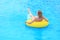 A beautiful young girl lies on an inflatable mattress in the summer water park.