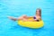 A beautiful young girl lies on an inflatable mattress in the summer water park.