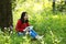 Beautiful young girl Listen to music on a mobile phone while sitting under giant oak