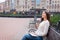 A beautiful young girl with long brown hair sitting on the bench with the book and eyeglasses in his hands. She left the house in