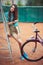 Beautiful young girl with longboard and bicycle standing on the