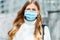 Beautiful young girl in a mask from coronovirus, student on the background of educational envy, women returning from work, close-