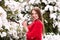 Beautiful young girl model in winter in a parked park. in a red sweater.