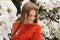 Beautiful young girl model in winter in a parked park. in a red sweater.