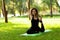 Beautiful young girl in park practices yoga and relaxes. Calm and tranquility