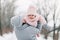 Beautiful young girl in a pink jumpsuit playing with her mother in a snowy winter park