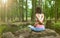 Beautiful young girl practicing yoga and meditation at sunrise in the forest. Shallow depth of field. Balance and spirituality