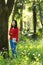 Beautiful young girl reading book while sitting under giant oak