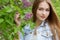 Beautiful young girl with red hair in the garden with lilac