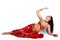 Beautiful young girl in a red suit oriental dance in motion isolated on white