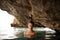 Beautiful young girl with redhead tied hair in the water cave