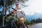 Beautiful young girl rides a bicycle on a beautiful mountain road. Summer holidays and cycling, sports and outdoor activities