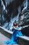 Beautiful young girl sits on a stone hedge against a background of a mountain massif and glacier