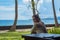 Beautiful young girl sits and waiting for a phone call on the veranda the bungalow on the ocean beach in Bali island Indonesia