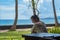 Beautiful young girl sits and waiting for a phone call on the veranda the bungalow on the ocean beach in Bali island Indonesia