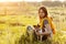 A beautiful young girl is sitting on the grass and hugging her dog. A girl and her pet are resting after a walk in nature. Friend