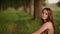 Beautiful young girl sitting near a tree, singing a song. Close-up.