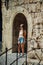 Beautiful young girl stand in the arc of ancient fort. Rhodes island, Greece summer.