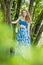 Beautiful young girl in a summer dress at sunset. Fashion photo in the forest. Model in a blue top and long skirt, with flowing cu