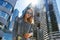 Beautiful young girl in sunglasses and denim in the contrasting rays of the sun on a background of skyscrapers.