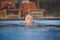 Beautiful young girl swim in a blue pool