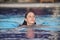 Beautiful young girl swim in a blue pool