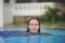 Beautiful young girl swim in a blue pool