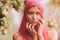 Beautiful young girl trying on a red scarf. Autumn time for harvest. Orchard. The concept of harvesting