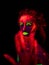 A beautiful young girl with ultraviolet paint on her body dancing in the dark. Pretty woman with glowing bodyart in