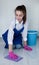 Beautiful young girl washes the floor with her hands. Bucket of water for cleaning. Vertical image.