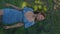 Beautiful young girl wearing feminine dress walking in green garden. Vertical handheld video. Natural beauty, travelling