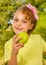 Beautiful young girl, wearing a yellow t-shirt holding a healthy apple and colorful dragees in her lips, in a blurred