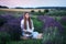 Beautiful young girl in white long dress on picnic read book in lavender field. Cute Little girl holding book on lavender field. P