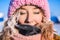 Beautiful young girl in a yellow down jacket and pink knitted cap with red hair in a frost in the background of the camp Barneo