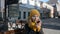 Beautiful young girl in a yellow knitted hat looks in a mirror on a bench in the city streets in Minsk