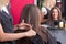 beautiful young hairdresser giving a new haircut to female customer