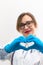 Beautiful young happy doctor woman in medical gloves and glasses with a stethoscope in the hospital shows hand gestures.