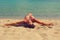 Beautiful young happy woman with tanned body in bikini relaxing