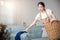 Beautiful young housekeeper maid doing housework holds basket wood of clean messy dirty clothes
