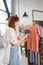 Beautiful young housewife irons clothes with a steamer at home.