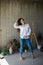 Beautiful young lady artist in white shirt dancing barefoot in her bohemian artistic studio loft