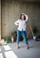 Beautiful young lady artist in white shirt dancing barefoot in her bohemian artistic studio loft