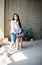 Beautiful young lady artist in white shirt sitting barefoot in her bohemian artistic studio loft