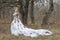 Beautiful young lady in gorgeous vintage white dress. Snow.