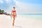 Beautiful, young lady in pink swimwear posing on the beach with a diving mask