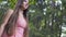 Beautiful young lady in red dress walks outdoors, brunette female in forest